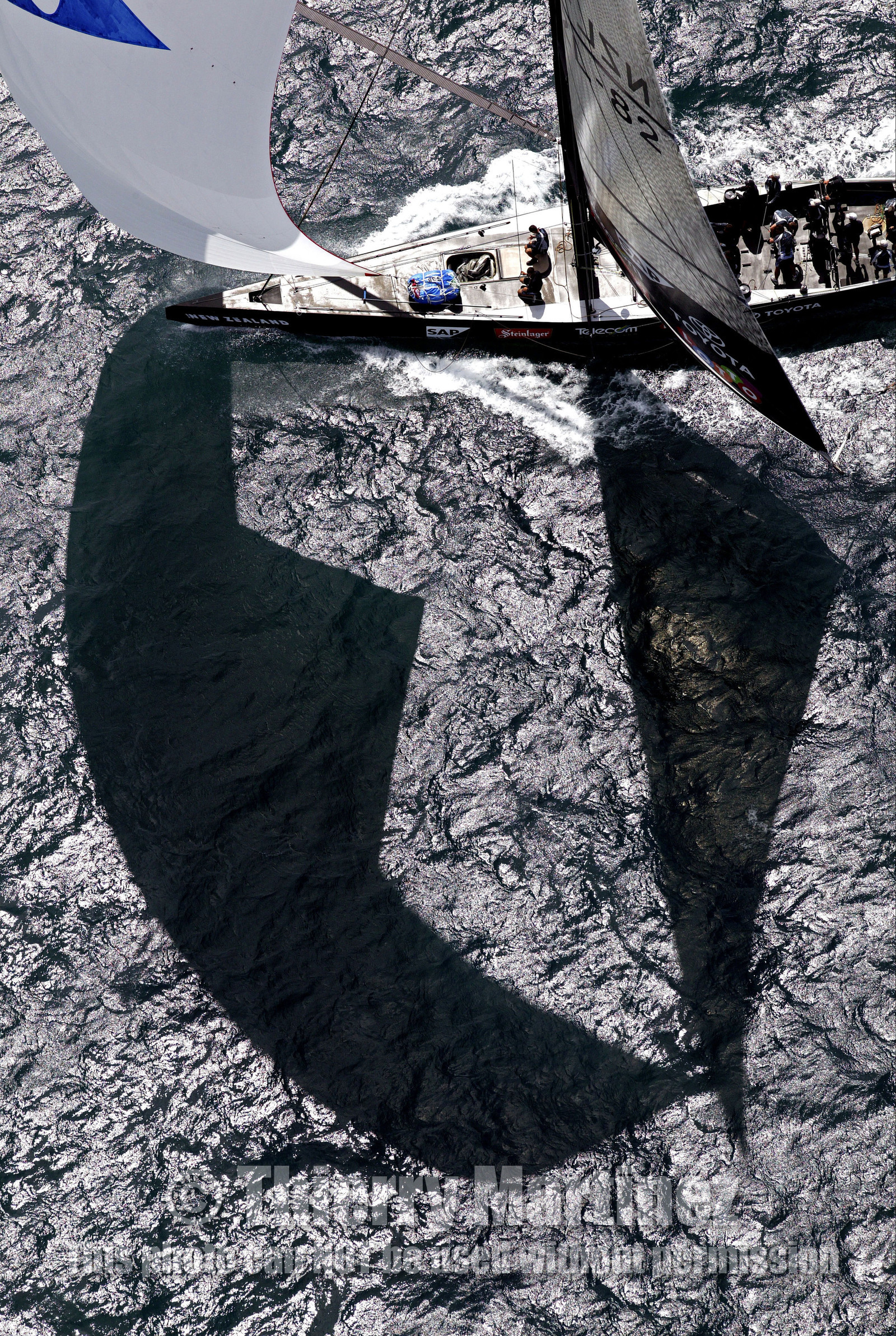 03_0204D ©Th.Martinez - Auckland (NZ) . America's Cup 2003. 18th February 2003. Day 3..Alinghi (SUI 64) vs Team NZ (NZL 82) .Team NZ's crew droping head sail in 2nd Downwind leg...