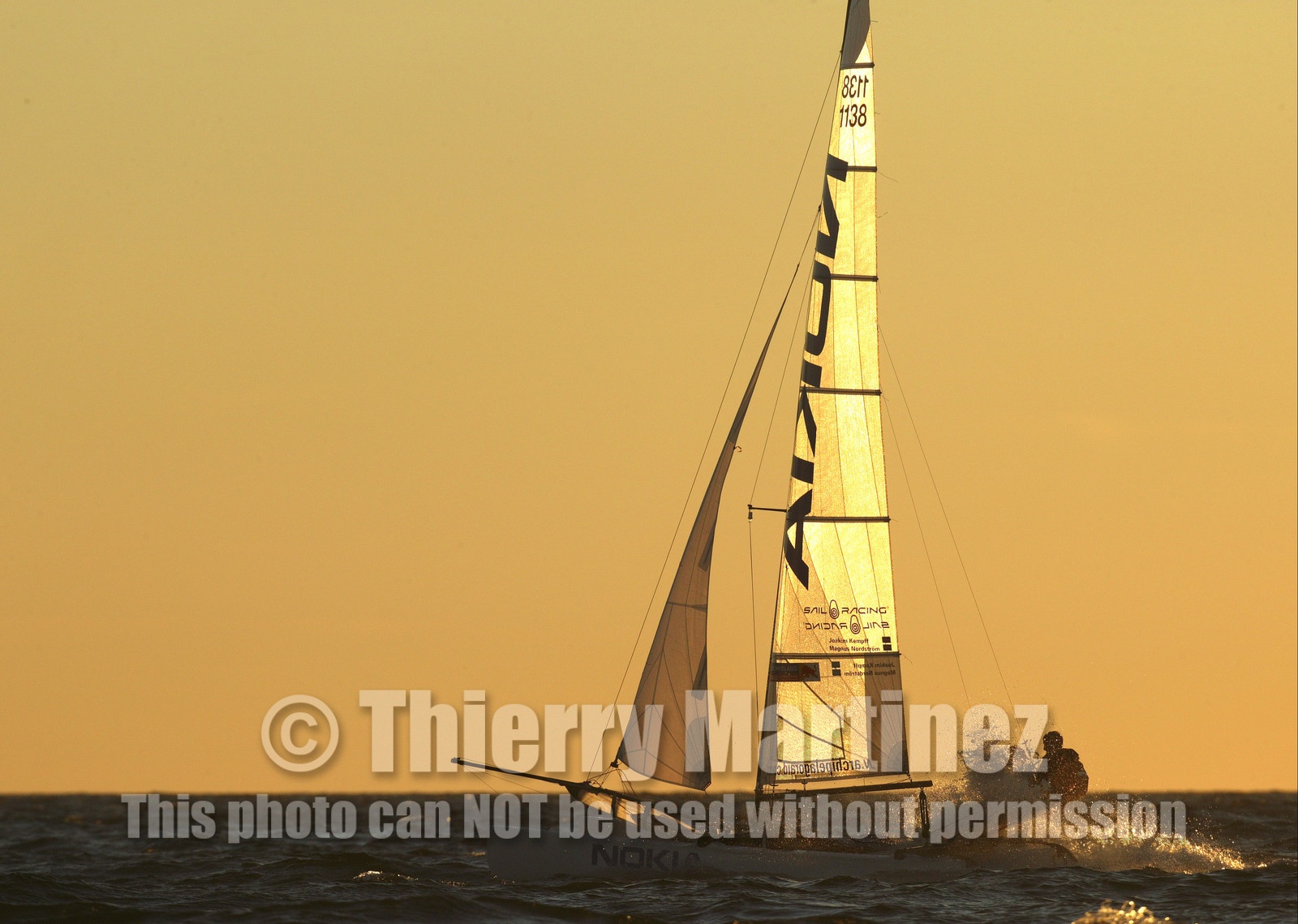 03_3231D © Th.Martinez,STOCKHOLM ARCHIPELAGO SWEDEN, 10 07 03-Archipelago Raid (2003)  Day 3..Team NOKIA-Kempff  Magnus Nordstrom (SWE)& Joakim Kempff (SWE) sailing in sunset light on the way back from Finland to Sweden.