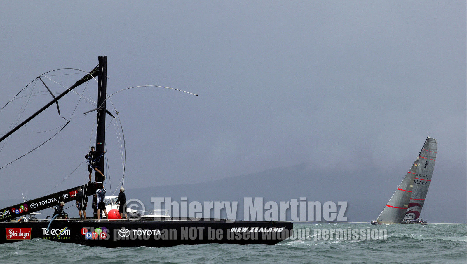 03_1127D © Th.Martinez. Auckland   New Zealand. 28th February 2003 America's Cup 2003. Day 4, Alinghi (SUI64) vs Team New Zealand (NZL82). SUI64 passing by NZL 82  with broken mast in race 4 .