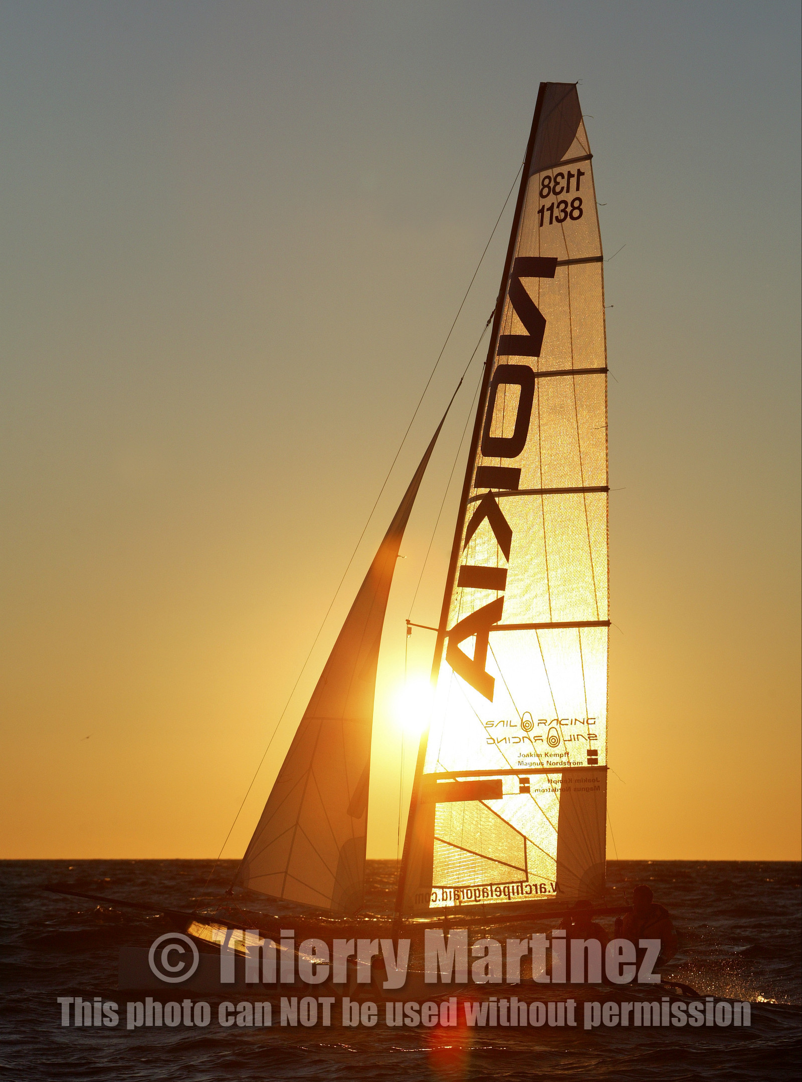 03_3248D © Th.Martinez,STOCKHOLM ARCHIPELAGO SWEDEN, 10 07 03-Archipelago Raid (2003)  Day 3..Team NOKIA-Kempff  Magnus Nordstrom (SWE)& Joakim Kempff (SWE) sailing in sunset light on the way back from Finland to Sweden.