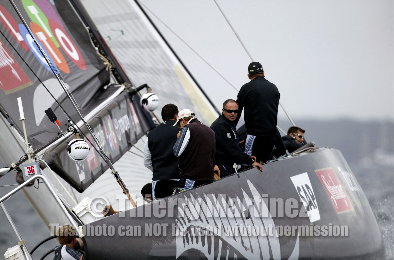 03_0241D ©Th.Martinez - Auckland (NZ) . America's Cup 2003. 20th February 2003. Day 4 Cancelled..Alinghi (SUI 64) vs Team NZ (NZL 82) .Team NZ's skipper Dean Barker at the helm of NZL 82, with frenchman Bertrand Pace (Tactician, on place of Hamish Pepper) for first time on board for America's Cup. Bertrand Pace is the first French sailor to race in n America's Cup match and is the helmsman of NZL 81. The race had been cancelled for wind not enough stable. Race 4 should start on Saturday 22th February...