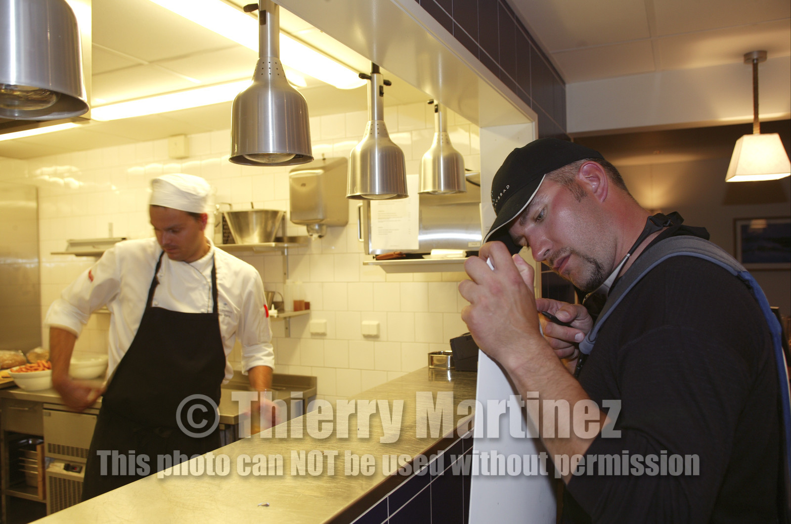 03_3172D © Th.Martinez,STOCKHOLM SWEDEN, 8 07 03-Archipelago Raid (2003).Nynäshamn..Stop in first HQ. Thomas Östergren (SWE) fixing his daggerboard in the kitchen of Nynäs-havsbad restauraunt.