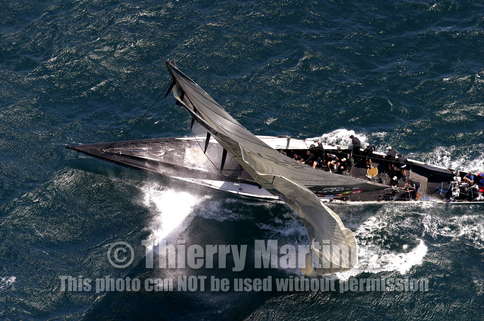 03_0182D ©Th.Martinez - Auckland (NZ) . America's Cup 2003. 15th February 2003. Day 1..Alinghi (SUI 64) vs Team NZ (NZL 82) . .NZL 82 head sails blowing up. Team NZ crew will set up an other head sails and retire after the second one blow up too.. Alinghi 1- Team NZ 0..