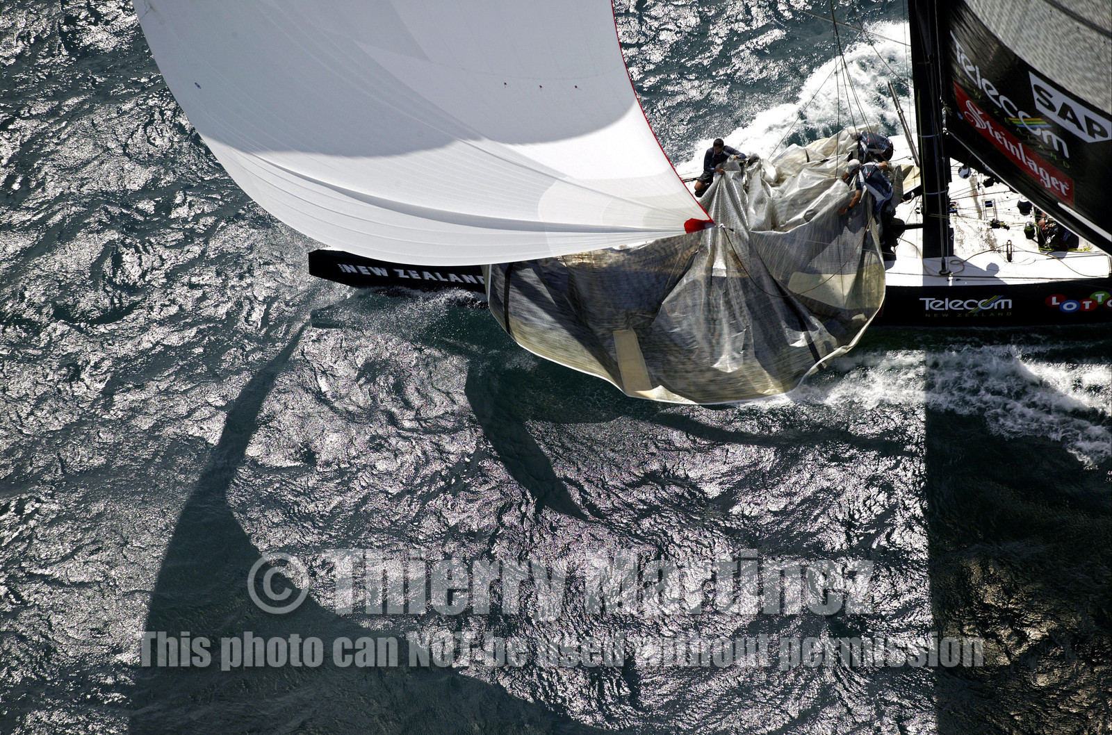 03_0200D ©Th.Martinez - Auckland (NZ) . America's Cup 2003. 18th February 2003. Day 3..Alinghi (SUI 64) vs Team NZ (NZL 82) .Team NZ's crew droping head sail in 2nd Downwind leg...