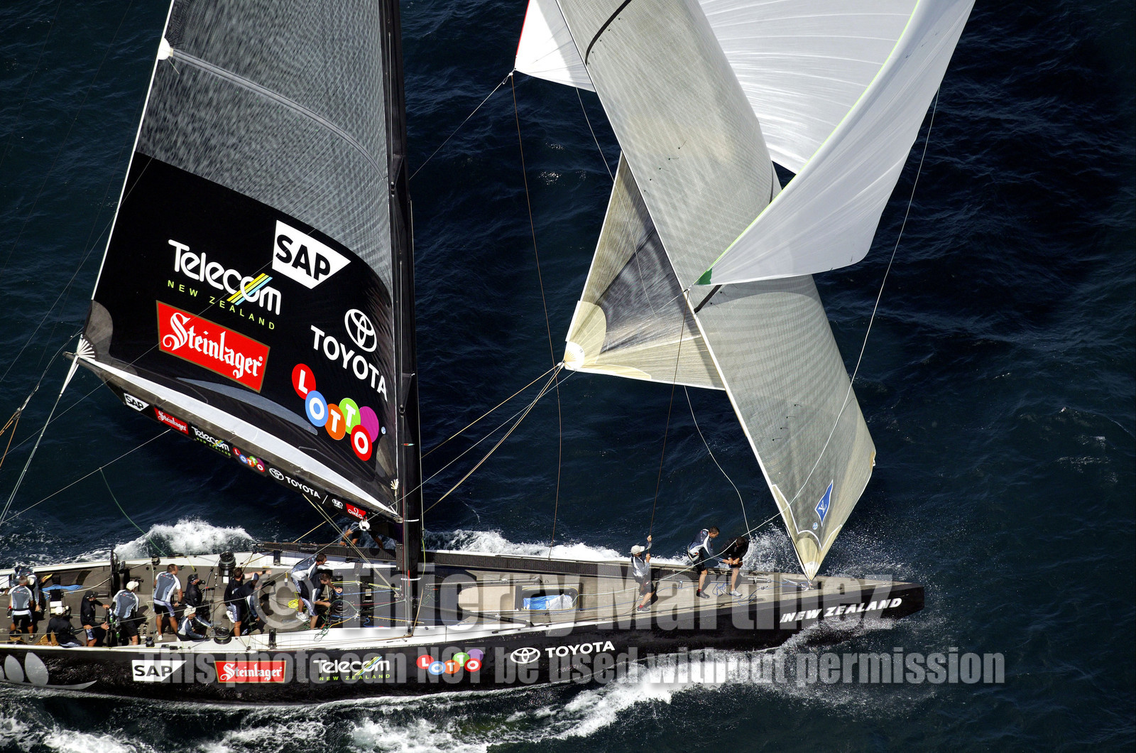 03_0195D ©Th.Martinez - Auckland (NZ) . America's Cup 2003. 18th February 2003. Day 3..Alinghi (SUI 64) vs Team NZ (NZL 82) .Team NZ 's crew droping head sail after setting up spinnaker at upwind mark...