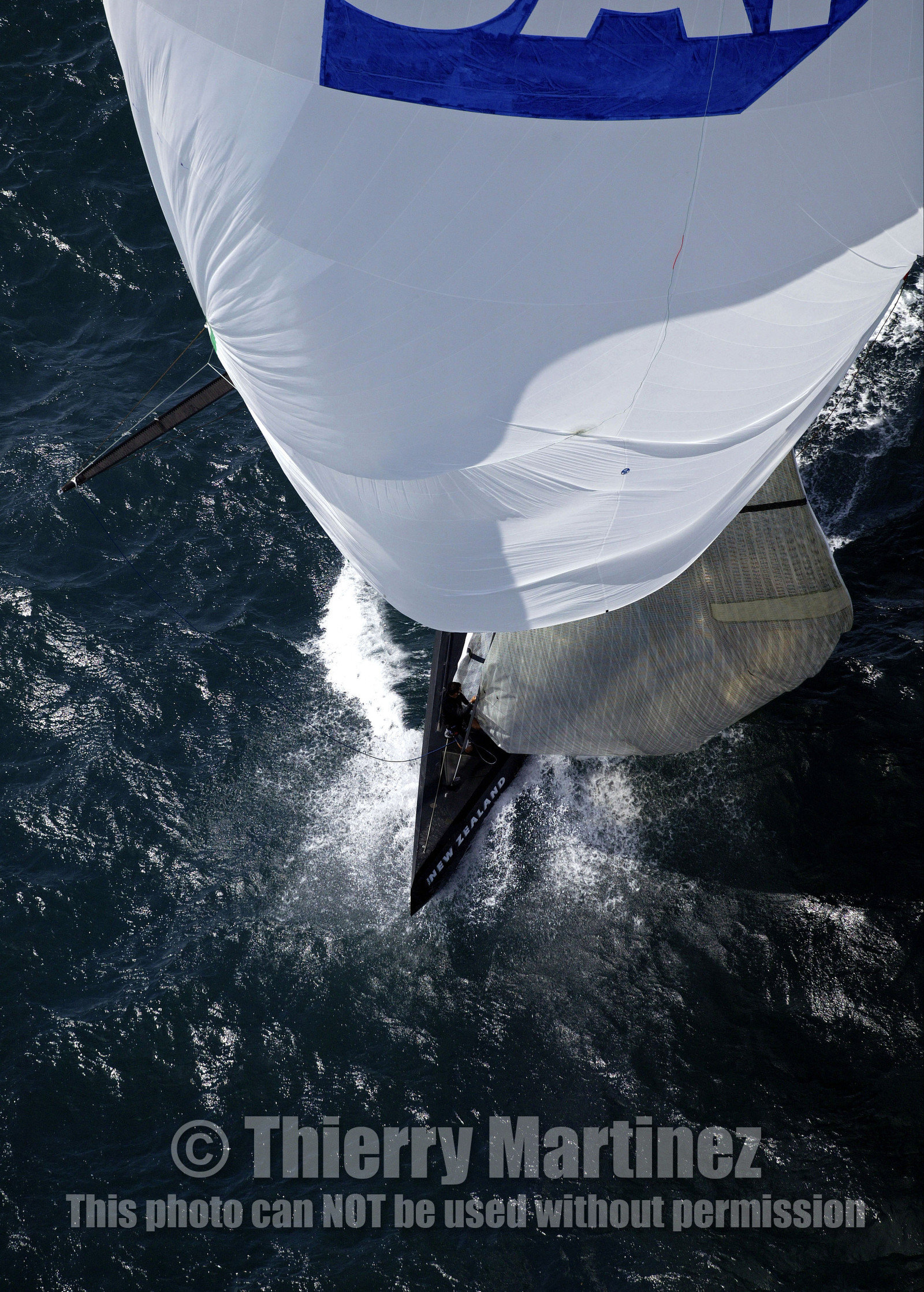 03_0197D ©Th.Martinez - Auckland (NZ) . America's Cup 2003. 18th February 2003. Day 3..Alinghi (SUI 64) vs Team NZ (NZL 82) .Team NZ 's crew droping head sail after setting up spinnaker at upwind mark....